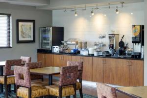 爱德蒙埃特德蒙拉昆塔套房酒店的厨房配有桌椅和柜台。