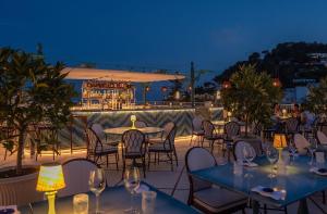 卡普里Hotel La Palma Capri, an Oetker Collection Hotel的庭院在晚上配有桌椅