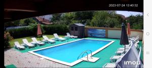 德瓦Noblesse House Deva的一个带草坪椅和遮阳伞的游泳池