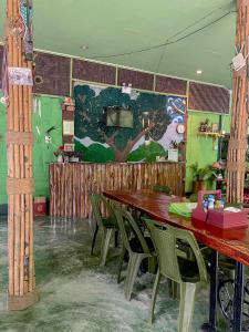 考索考索绿色山景度假村的用餐室配有木桌和绿色椅子