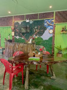 考索考索绿色山景度假村的配有木桌、椅子和壁画的房间