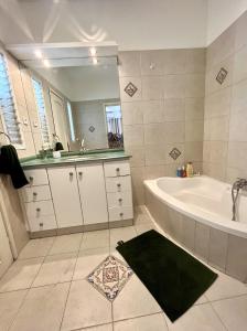 特拉维夫Neve Tsedek Rooftop的带浴缸、水槽和镜子的浴室