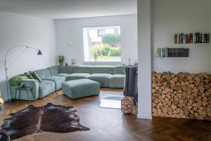 BleckhausenEifel21 - stilvolles Haus in der Vulkaneifel的客厅配有沙发和一堆木头