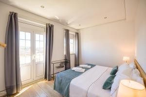 波尔图Feel Porto Historical Apartments的一间卧室设有一张床和一个大窗户