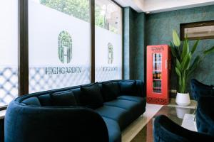 第比利斯Highgarden Hotel的客厅配有黑色沙发和红色电话亭