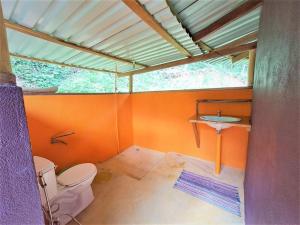 蓬塔乌巴Terra NaturaMa - off grid living in the jungle的橙色浴室设有卫生间和水槽