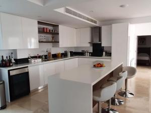 PaphosLuxury 6 bedrooms villa in Cyprus的厨房配有白色橱柜和带椅子的柜台。