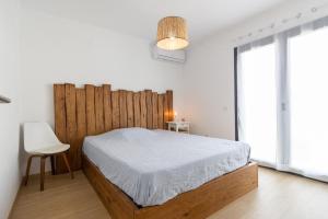 米尔芳提斯城PÉ NA AREIA II by Stay in Alentejo的一间卧室配有一张带木制床头板的床