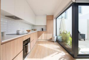 米尔芳提斯城PÉ NA AREIA II by Stay in Alentejo的一个带木制橱柜和大窗户的厨房