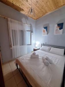 阿亚安娜Lovely Guesthouse On The Beach的卧室配有白色的床和2条毛巾