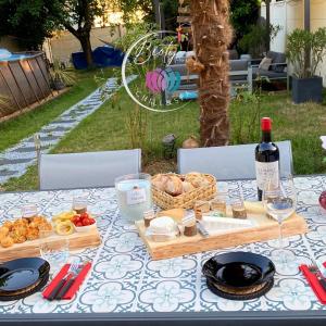 勒布朗-梅尼尔BIOTY CHILL & SPA的一张桌子,上面放着一盘食物和一瓶葡萄酒