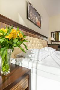 德鲁斯基宁凯列图瓦SPA豪华酒店列图瓦的一张桌子上床边的黄色花瓶