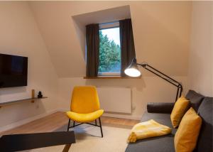 鲁尔河畔米尔海姆Renoviertes Design Apartment mit Toller Terasse的带沙发和黄色椅子的客厅