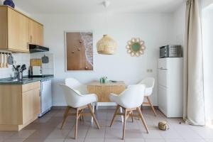 沃伦伯格Haus Seeblick Wohnung 13 "Green Island的厨房配有白色的椅子和木桌