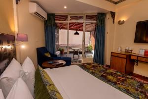 瑞诗凯诗GANGA KINARE- A Riverside Boutique Resort, Rishikesh的酒店客房带一张床、一张桌子和椅子