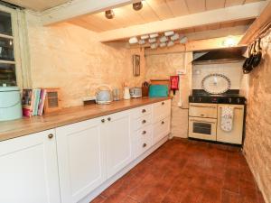 赫尔斯顿Pentira的厨房配有白色橱柜和炉灶。