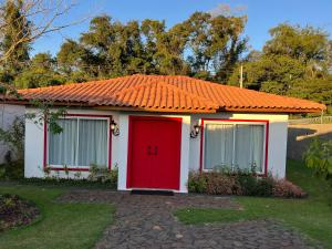 伊瓜苏Alma Iguassu的一座带橙色屋顶和红色门的小房子