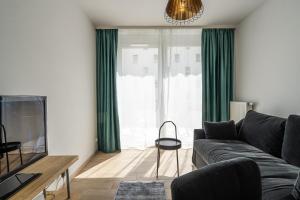 弗罗茨瓦夫RentPlanet - Apartament Braniborska的带沙发和绿色窗帘的客厅