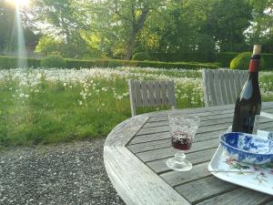 Huisseau-sur-CossonLa Taille de Biou的一瓶葡萄酒和一张木桌上的玻璃杯