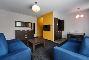 格但斯克金郁金香格但斯克公寓酒店的客厅配有2张蓝色的沙发和1张桌子