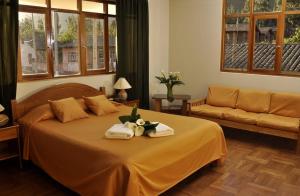 乌鲁班巴波萨达特莱斯玛丽亚酒店的一间卧室配有带毛巾和沙发的床