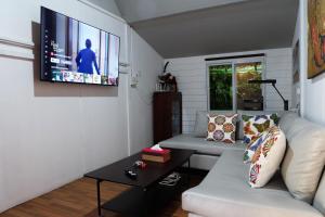 清迈Baan Wassana In The City Old Moat的客厅配有白色沙发和平面电视。