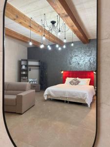 纳杜尔Sea Holly Gozo的一间卧室配有红色的床和一张沙发