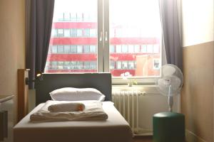 汉堡Hostel City Süd的一间卧室配有一张床和一个带风扇的窗户。