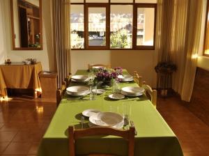 乌鲁班巴波萨达特莱斯玛丽亚酒店的一张桌子,上面有绿桌布,盘子和花