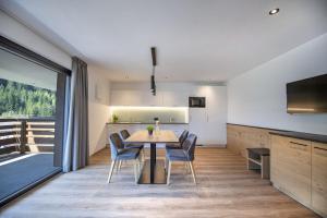 塞尔瓦迪加尔代纳山谷Apartments Chalet Silva的用餐室以及带桌椅的厨房。