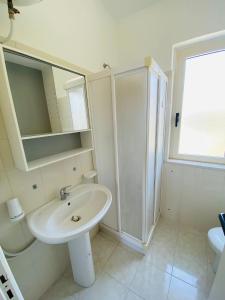 帕尔盖利亚Marasusa Apartments Scirocco的白色的浴室设有水槽和淋浴。