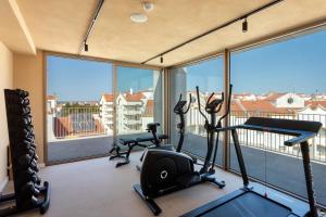 阿尔科谢蒂Upon Vila - Alcochete Hotel的一个带两台跑步机和健身自行车的健身房,位于带窗户的房间