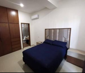 马萨特兰Hermoso alojamiento vacacional的一间卧室配有蓝色的床和镜子