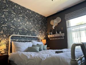 塔维斯托克One Drake Road, Tavistock, Devon的一间卧室配有一张带花卉图案墙壁的床