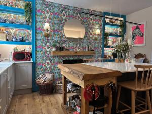 塔维斯托克One Drake Road, Tavistock, Devon的厨房设有蓝色的墙壁和一张带镜子的桌子