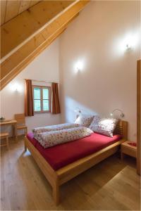 洛伊查赫Gästehaus Biohof Leutschach的一间卧室配有一张带红色毯子的大床
