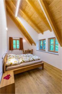 洛伊查赫Gästehaus Biohof Leutschach的一间带一张床的卧室,位于带木制天花板的房间内