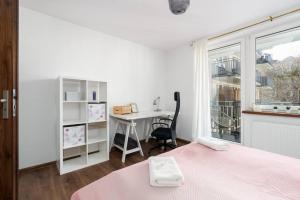 波兹南Kosińkiego Apartament Poznań by Renters的一间卧室配有一张床、一张书桌和一个窗户。