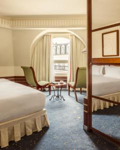 巴黎Hôtel Des Grands Voyageurs的酒店客房设有两张床和窗户。