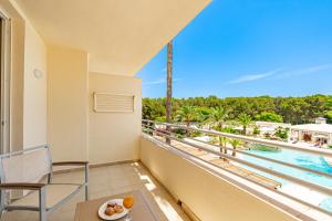 萨科马Hotel Rosella affiliated by Intelier的享有游泳池和棕榈树景致的阳台