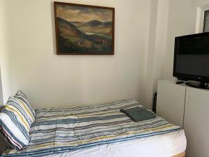 欧尔菲SunShine Apartman的卧室配有一张床,墙上挂有绘画作品