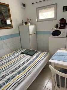 欧尔菲SunShine Apartman的小房间设有一张床和一台冰箱