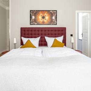 诺伊鲁平Up Hus Hotel Neuruppin的卧室配有一张带黄色枕头的大型白色床。