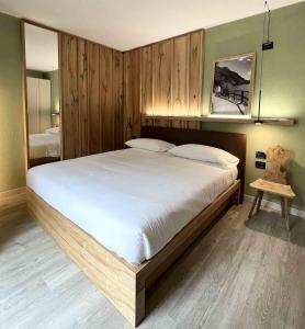 迪马罗阿尔贝格迪马洛健康酒店的一间卧室配有一张带木墙的大床
