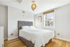 伦敦Stylish 2 FLOOR 2BED house 1 MIN walk to Camden station! FREE PARKING!的一间卧室设有一张大床和一个窗户。