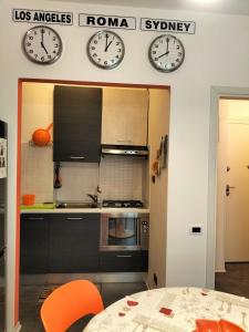 龙基德伊莱焦纳里Tre Continenti - Appartamento con parcheggio privato的厨房设有两把墙上的时钟和一张桌子