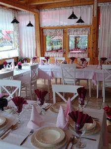泽高杰耶泽尔斯科Penzion Valerija的用餐室配有白色桌椅和粉红色餐巾