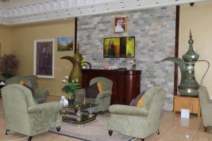 沙迦沙迦国际机场酒店的客厅配有两把椅子和一张桌子