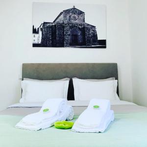 波瓦-迪瓦尔津Casa da Vila Guest House的一张带白色毛巾的床和黑白建筑