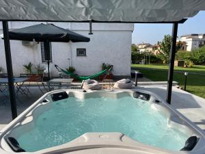 CorchianoLa Petite Famille的庭院内的热水浴池和遮阳伞